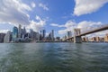 Beautiful view from Hudson River of Brooklyn Bridge and skyscrapers of Manhattan against backdrop of blue sky with white clouds. Royalty Free Stock Photo