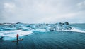 Beautiful view of icebergs glacier lagoon with a guy paddle boarding sup Royalty Free Stock Photo