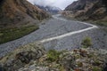 Beautiful view on impressive gorge in Caucasus mountains. Monument in form of Cross and path to it