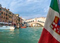 Beautiful view of Italian maritime flag and bridge of Rialto or ponte Rialto on Grand Canal on Venice, Italy. Gondola