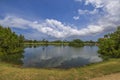 Beautiful view of lake and green golf courses on island of Aruba on blue sky with white clouds background. Royalty Free Stock Photo