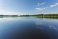 Beautiful view on lake on summer day. Dark blue lake water surface, green tall trees and blue sky with white clouds. Sweden, Royalty Free Stock Photo