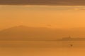 Beautiful view of a lake at sunset, with orange tones, birds on water and a man on a canoe Royalty Free Stock Photo