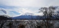 Beautiful view of landscape. Branch of tree with Fuji mountain, lake, clouds and blue sky background with above copy space. Royalty Free Stock Photo