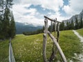 Beautiful view on landscape of Dolomites moutains and a gree forest through wooden fences with some wood constraction on