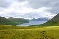 Beautiful view of a large green pasture sloping down towards the blue ocean.