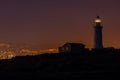 Beautiful view of a lighthouse and a house on a hill captured at night in Cyprus