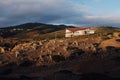 Beautiful view of a lonely building on a rocky crag with the mountains in the background