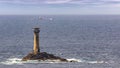 A tanker passing by the sea behind the Longships lighthouse.