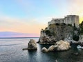 A beautiful view of the Lovrijenac tower, black water bay, and the adriatic sea in Dubrovnik, Croatia during sundown. Royalty Free Stock Photo