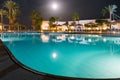 Beautiful view of the luxurious hotel pool in the moonlight. Rest area at an expensive resort. Swimming pool at night in one of Royalty Free Stock Photo