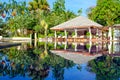 Beautiful view on luxury swimming pool. Chairs, umbrella and palm trees reflected in water Royalty Free Stock Photo