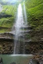 Beautiful view of Madakaripura waterfall with green moss and blue sky in Java, Indonesia Royalty Free Stock Photo