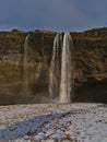 Beautiful view of majestic waterfall Seljalandsfoss on the southern coast of Iceland with colorful rainbow on sunny day.