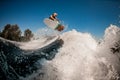 Beautiful view of man on surf style wakeboard masterfully jumping over splashing wave Royalty Free Stock Photo