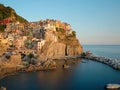 Beautiful view of Manarola at sunset, with water between the rocks in the lower part forming a blue heart