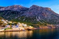 Beautiful view of Mediterranean island at sunset. Small Greek fisherman village in rays of low sun. Sun flares Royalty Free Stock Photo