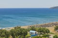 Beautiful view of Mediterranean sea sand beach with sunbeds and sun umbrellas on background. Rhodes. Royalty Free Stock Photo