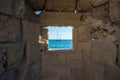 Beautiful view of mediterranean sea with a ship, framed by a window on Rhodes city walls. Greece