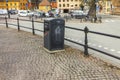 Beautiful view of metal waste container on cobblestone pavement of European city. Sweden.