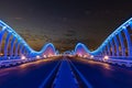 Beautiful view of Meydan Bridge in Dubai. Modern artistic bridge in Dubai. Night architectural shot of a bridge with curvy blue li