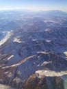 beautiful view of the mountains and blue sky from the window of a flying plane Royalty Free Stock Photo