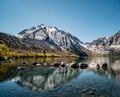 Beautiful view of the mountains over the calm lake water with a row of stones on the water surface Royalty Free Stock Photo