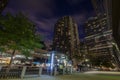 Beautiful view of New York City with glowing blue lights at a bus stop surrounded by tall buildings Royalty Free Stock Photo