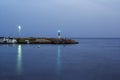 Beautiful view of the night coast. A small lighthouse shines. Water is blurry at long exposure