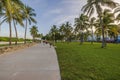 Beautiful view of Ocean Drive in Miami Beach park area with people strolling along park paths at sunset. Royalty Free Stock Photo