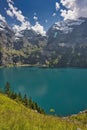 Beautiful view of Oeschinensee, Oeschinen Lake by Kandersteg, Switzerland. Turquoise lake with steep mountains and rocks in ba