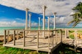 Beautiful view of old wedding gazebo columns standing on stylish wooden deck near the beach and tranquil ocean