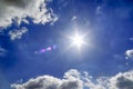 Beautiful view onto sunbeams with some lens flares and clouds on a blue sky