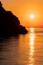 Beautiful view of orange sunset with rocks in Calabria, Mediterranean Sea, Italy. Tropical colorful sunrise landscape