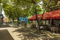 Beautiful view of outdoor cafe on one of Willemstad streets. Beautiful buildings and green trees on background.