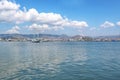 Beautiful View Over the Calm Sea Water Accompanied by Floating Boats Large Mountains with Clear Cloudy Blue Sky Background Royalty Free Stock Photo