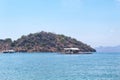 Beautiful View Over the Calm Sea Water Accompanied by Floating Boats and Large Mountains with Clear Cloudy Blue Sky Background Royalty Free Stock Photo