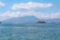 Beautiful View Over the Calm Sea Water Accompanied by Large Mountains with Clear Cloudy Blue Sky Background Royalty Free Stock Photo