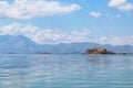 Beautiful View Over the Calm Sea Water Accompanied by Large Mountains with Clear Cloudy Blue Sky Background Royalty Free Stock Photo