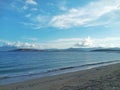 Beautiful View Over the Calm Sea Water During Sunny Weather Accompanied by Large Mountains with Clear Cloudy Blue Sky Background Royalty Free Stock Photo