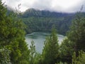 Beautiful View over Lagoa de Santiago Lake with green trees and hills coved by fog from Miradouro do Cerrado das Freiras