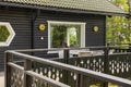 Beautiful view of part facade of typical wooden Swedish house with wooden patio.