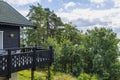 Beautiful view of part facade of typical wooden Swedish house with wooden patio.