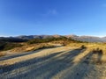 Beautiful view of the pathway with the edge of the hill covered in grass and the mountains in front Royalty Free Stock Photo