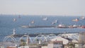 Beautiful view of pier with many ships in sea. Action. Large ships sail at suburban sea pier on sunny day. Fishing and