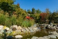 Beautiful view of pond with cascading waterfall and red bridge in Japanese garden. Public landscape park of Krasnodar or Galitsky Royalty Free Stock Photo