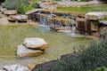 Beautiful view of pond decorated with big rocks. Clear water mirror surface effect Royalty Free Stock Photo