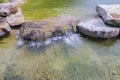 Beautiful view of pond decorated with big rocks. Clear water mirror surface effect Royalty Free Stock Photo