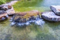 Beautiful view of pond decorated with big rocks. Clear water mirror surface effect