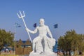 Beautiful view of Poseidon sculpture on Greek flags and blue sky background. Rhodes. Royalty Free Stock Photo
